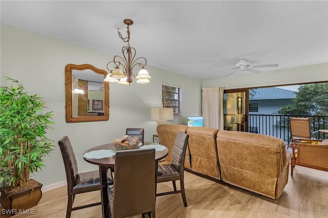 dining area with ceiling fan with notable chandelier and light hardwood / wood-style floors