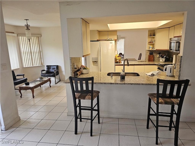 kitchen with a kitchen breakfast bar, kitchen peninsula, sink, and appliances with stainless steel finishes