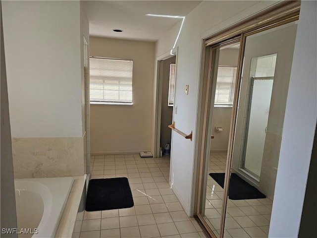 bathroom featuring tile patterned flooring, plenty of natural light, and tiled tub