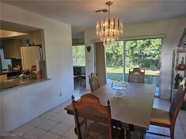 dining space featuring light tile patterned floors and an inviting chandelier