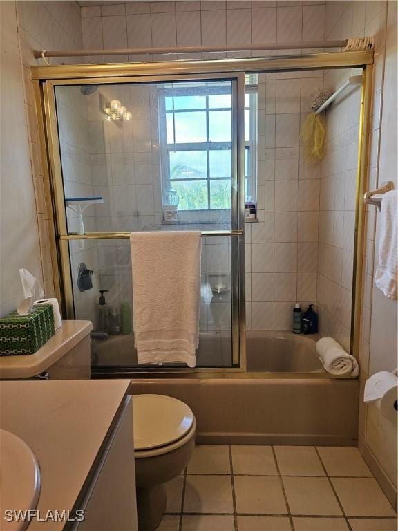 full bathroom with toilet, tile patterned flooring, vanity, and combined bath / shower with glass door