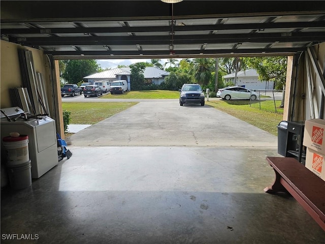 garage with washing machine and dryer and a lawn