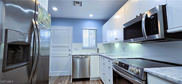 kitchen with appliances with stainless steel finishes, sink, and white cabinets