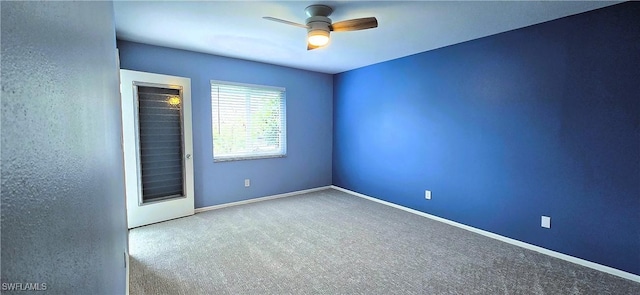 carpeted spare room with ceiling fan