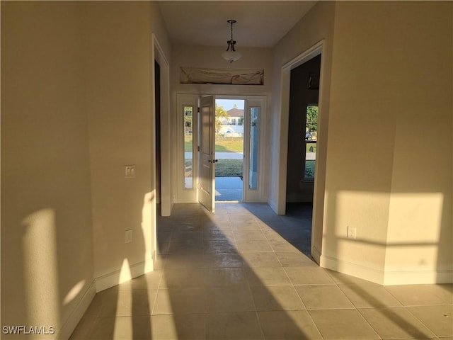 corridor with tile patterned flooring and baseboards