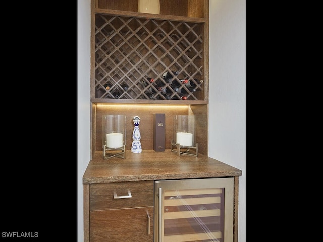 wine room with wine cooler and bar