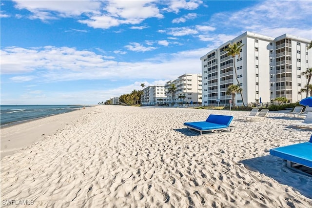 view of community with a water view and a beach view