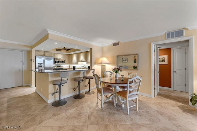 dining space featuring ceiling fan and ornamental molding