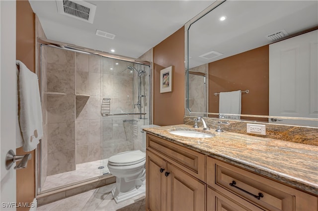 bathroom with vanity, a shower with shower door, and toilet