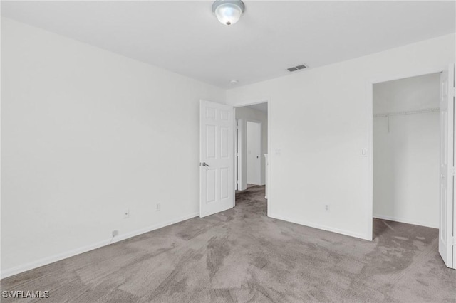 unfurnished bedroom featuring light carpet and a closet