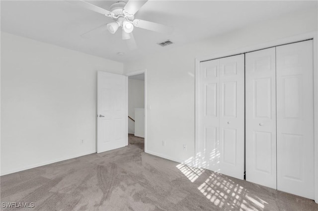 unfurnished bedroom featuring ceiling fan, a closet, and light colored carpet