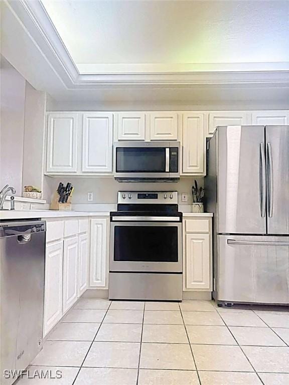 kitchen with sink, light tile patterned flooring, white cabinets, and appliances with stainless steel finishes