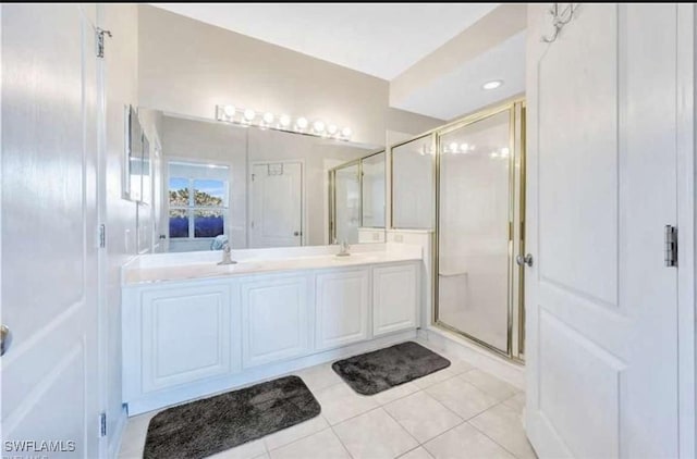 bathroom featuring tile patterned floors, an enclosed shower, and vanity