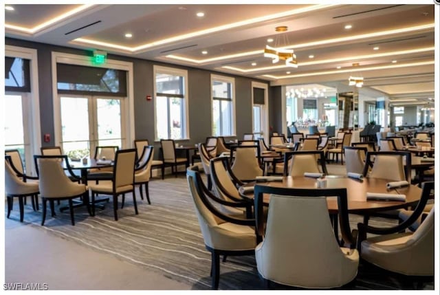 dining space with a tray ceiling and french doors