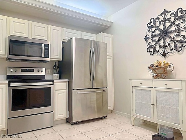 kitchen with stainless steel appliances, white cabinetry, and light tile patterned floors