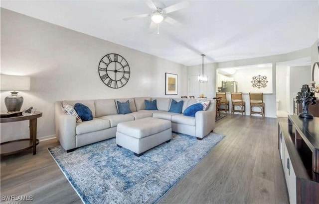 living room featuring wood-type flooring and ceiling fan