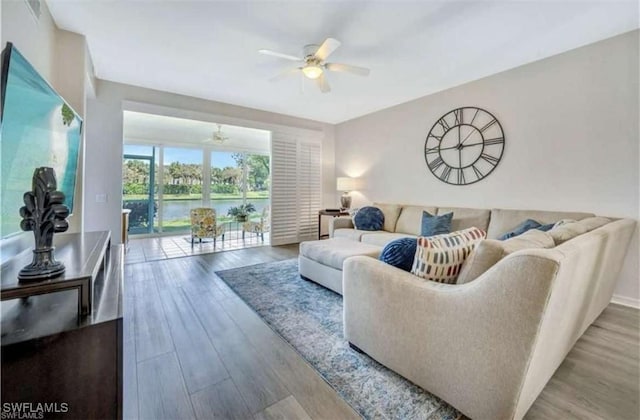 living room featuring a water view, ceiling fan, and hardwood / wood-style floors