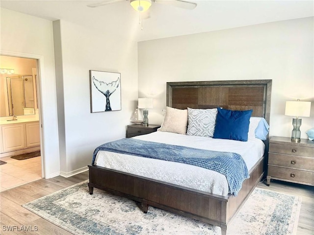 bedroom featuring ensuite bath, light hardwood / wood-style flooring, and ceiling fan