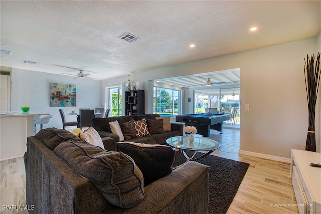 living room featuring ceiling fan, light hardwood / wood-style flooring, a textured ceiling, and billiards