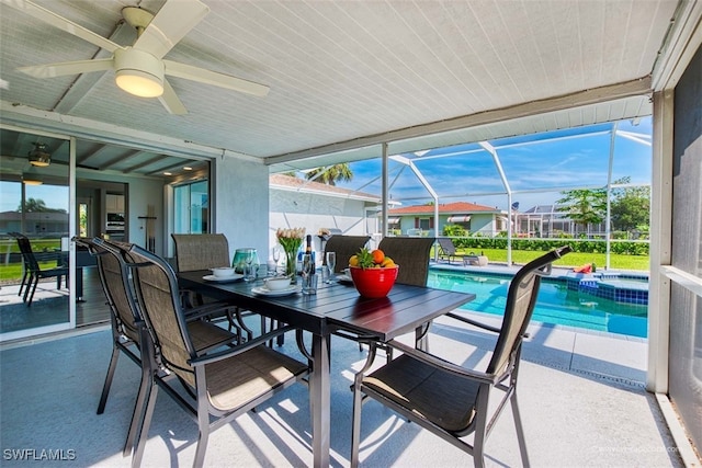 sunroom with ceiling fan, a healthy amount of sunlight, and a pool