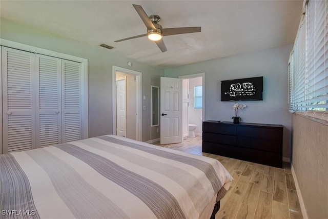 bedroom with ensuite bath, ceiling fan, a closet, and light hardwood / wood-style floors