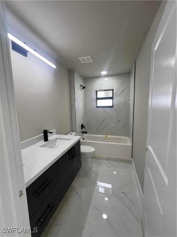 full bathroom with tiled shower / bath combo, toilet, and vanity