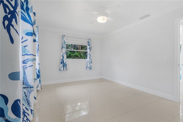 empty room featuring ceiling fan, light tile patterned floors, and ornamental molding