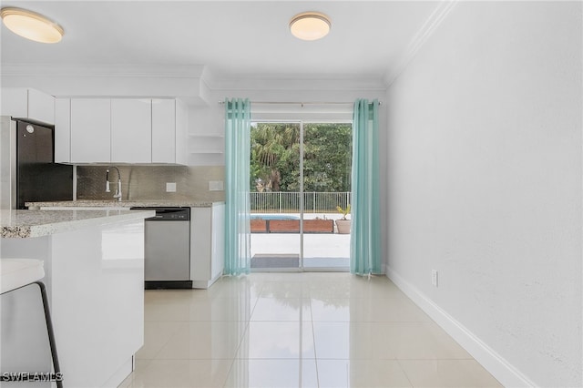 kitchen featuring white cabinetry, backsplash, crown molding, light tile patterned floors, and appliances with stainless steel finishes