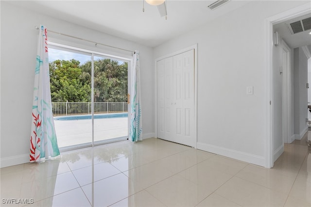 unfurnished bedroom with access to exterior, light tile patterned floors, a closet, and ceiling fan