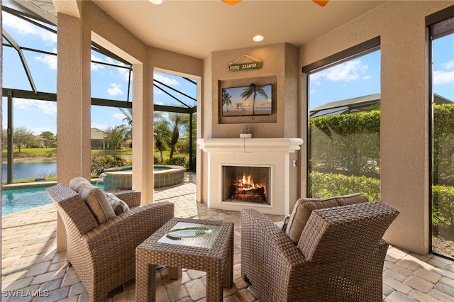 sunroom featuring a water view and exterior fireplace