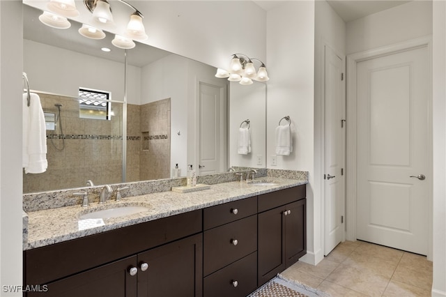 bathroom featuring tile patterned flooring, vanity, a tile shower, and a notable chandelier