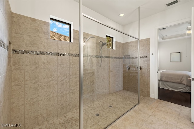 bathroom with tile patterned flooring, ceiling fan, and tiled shower