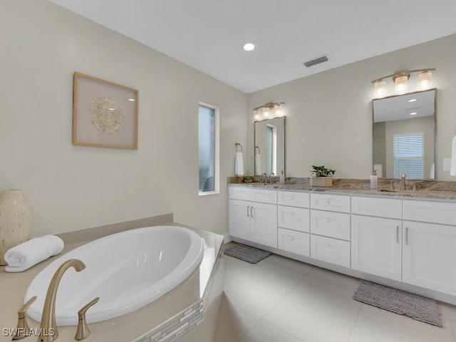 bathroom with tile patterned floors, a relaxing tiled tub, and vanity