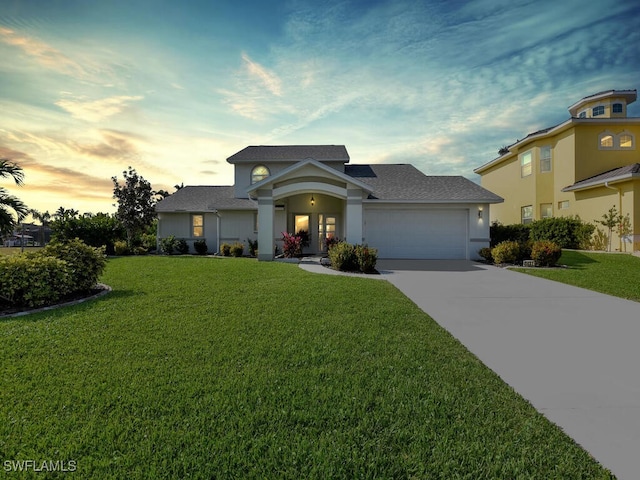 view of front of property with a garage and a yard