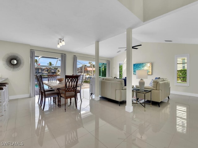 dining space with vaulted ceiling, ceiling fan, and light tile patterned floors