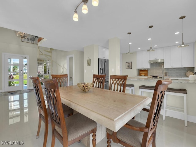 tiled dining room with a chandelier