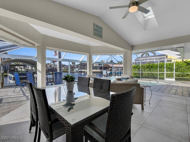 sunroom / solarium featuring ceiling fan, a wealth of natural light, a water view, and vaulted ceiling