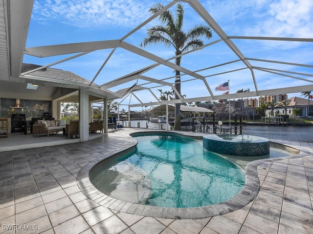 view of pool featuring glass enclosure, an outdoor hangout area, and a patio