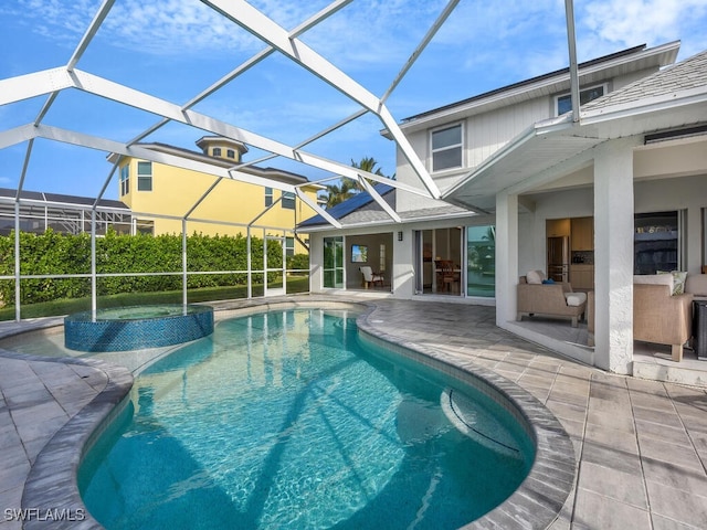 view of pool with glass enclosure, an outdoor bar, and a patio