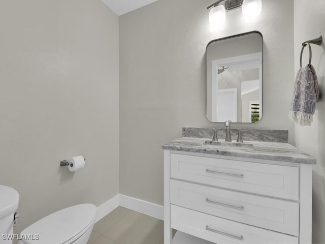 bathroom featuring toilet, vanity, and tile patterned flooring