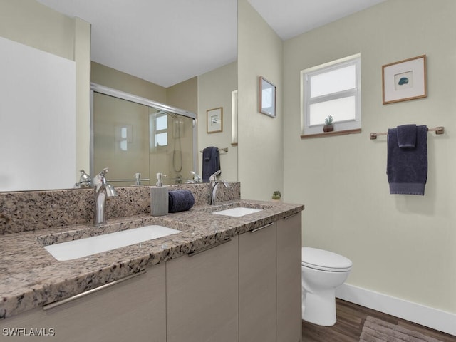 bathroom with vanity, toilet, hardwood / wood-style flooring, and an enclosed shower