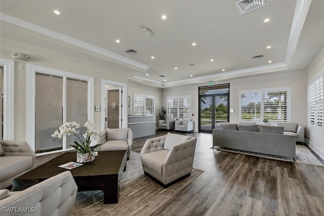 living room with hardwood / wood-style floors and a tray ceiling