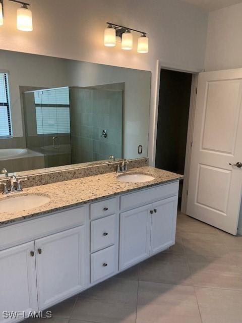 bathroom with tile patterned flooring, vanity, and a shower with shower door