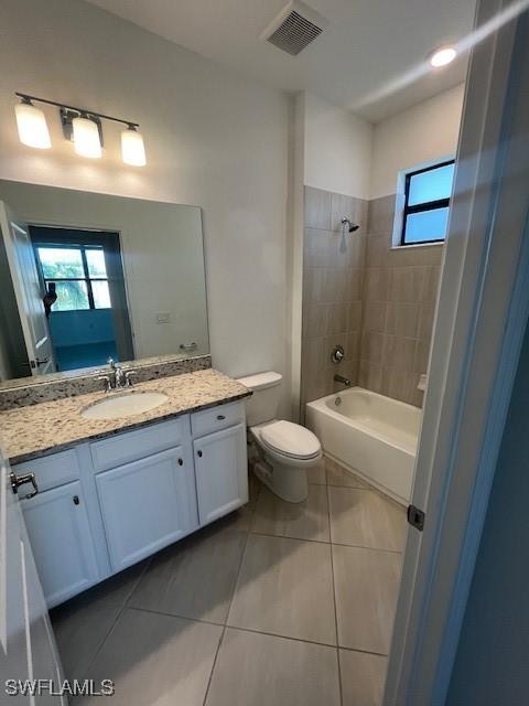 full bathroom featuring toilet, vanity, tile patterned floors, and tiled shower / bath