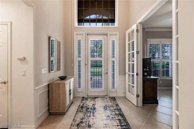 tiled entrance foyer featuring ornamental molding and french doors