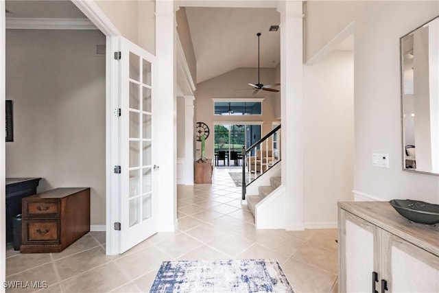 foyer entrance featuring light tile patterned floors, vaulted ceiling, ceiling fan, and crown molding