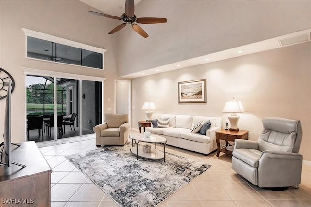 tiled living room featuring ceiling fan and a high ceiling