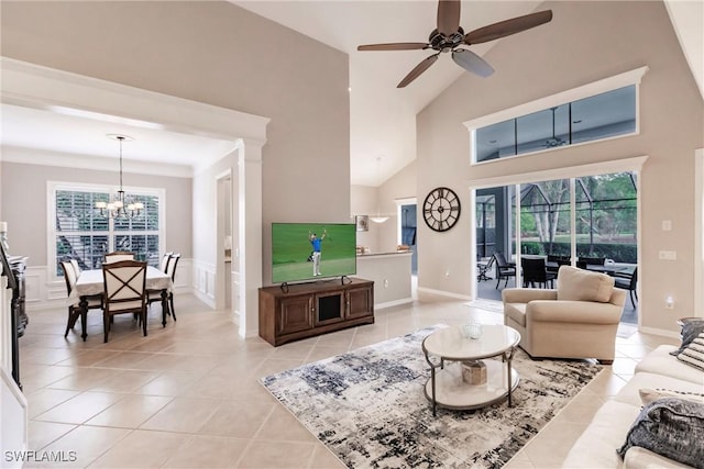 living room with light tile patterned floors, ceiling fan with notable chandelier, and vaulted ceiling