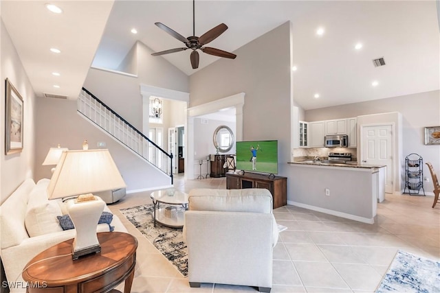 tiled living room featuring ceiling fan and high vaulted ceiling