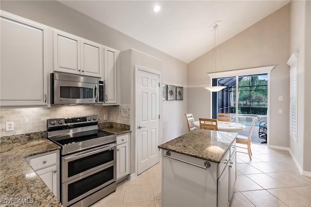 kitchen with white cabinetry, light stone counters, hanging light fixtures, and stainless steel appliances